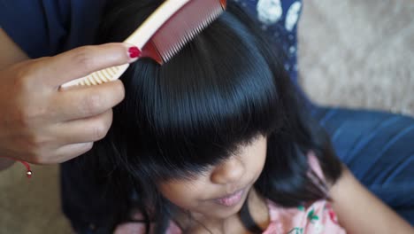 mother combing daughter's hair