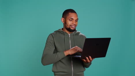 Man-scrolling-on-laptop,-using-internet-and-credit-card-to-pay-for-products