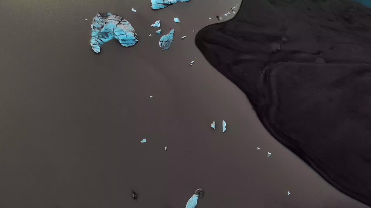 A glacier lake that is black because of the cryconite. Some of the white and blue ice parts show a nice contrast. Snæfellsjökull galcier in Iceland.