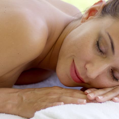 mujer relajándose en la mesa de spa en el patio al aire libre