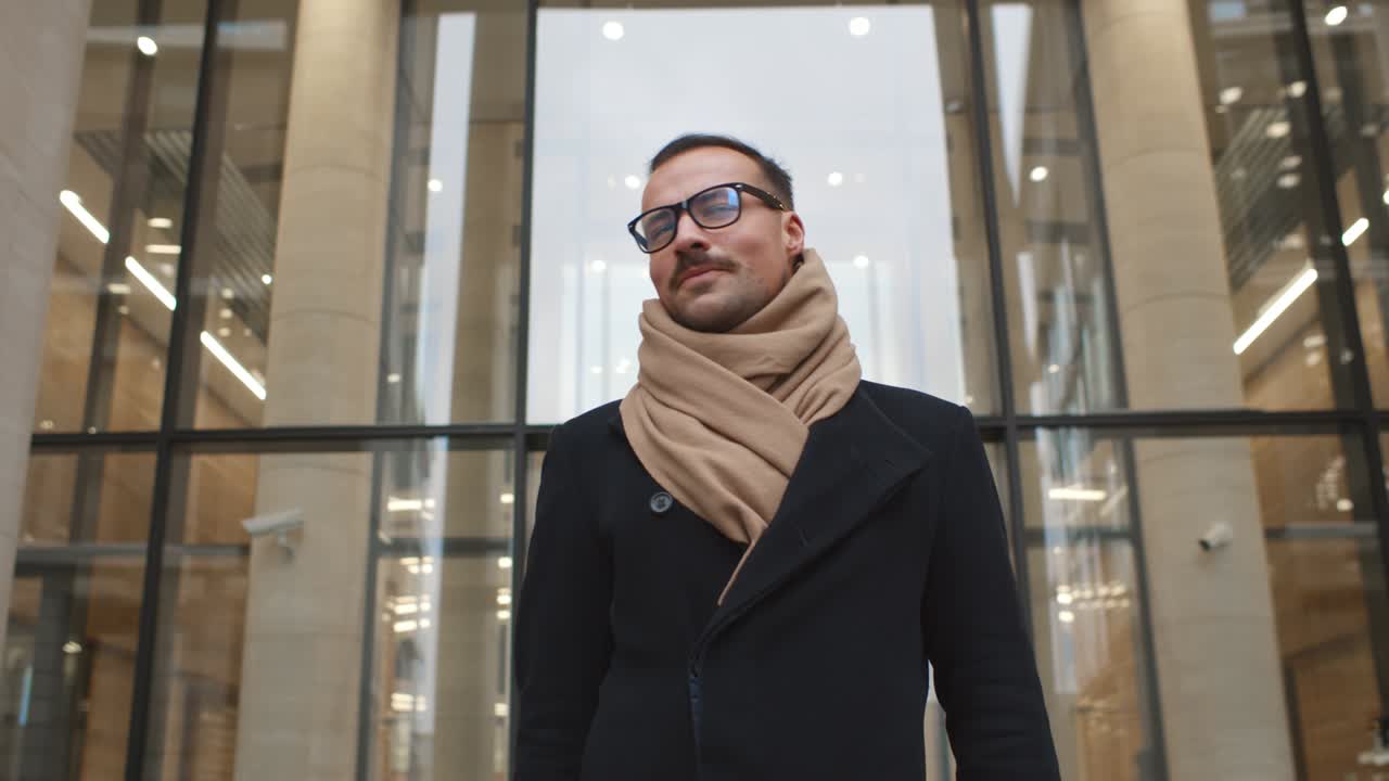 Handsome stylish businessman walking out of business center
