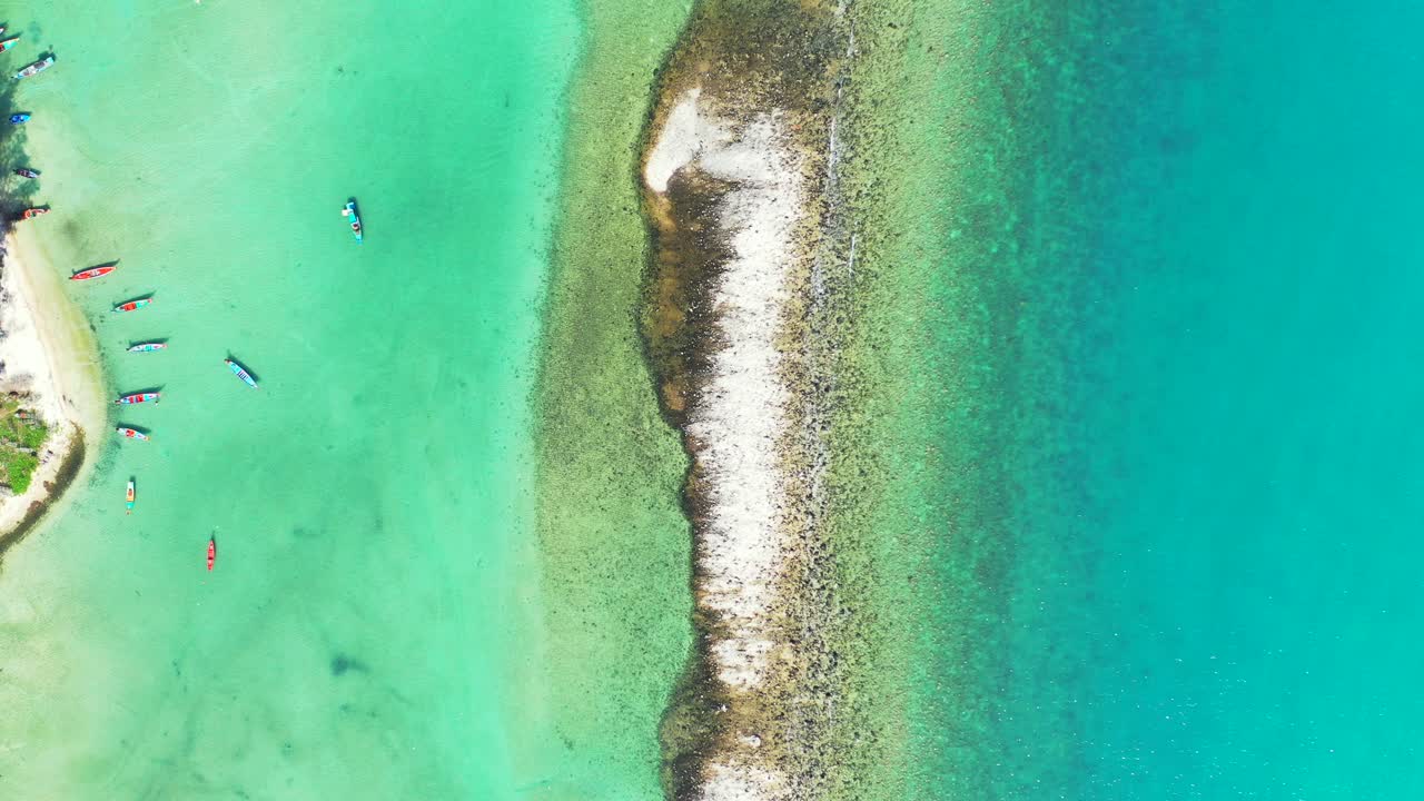 Beautiful barrier made of coral reefs and rocks surrounded by calm clear water of turquoise lagoon where boats anchoring in Vietnam