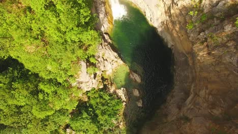 Gente-Nadando-En-El-Río,-Cascada-Y-Rocas-A-Su-Alrededor