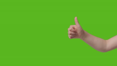 Close-Up-Of-Child-Giving-Thumbs-Up-Gesture-To-Camera-Against-Green-Screen