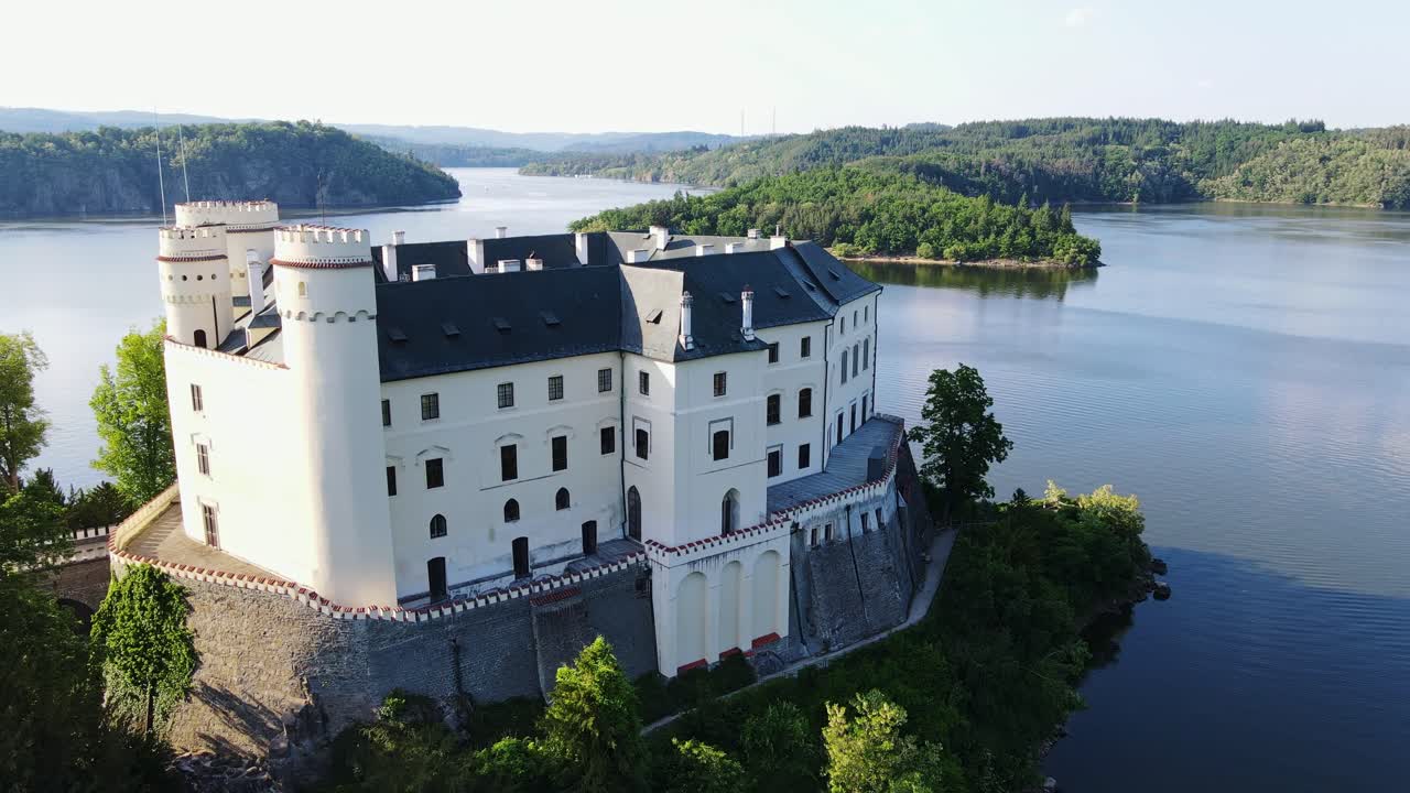 Orlík Castle on Vltava river seen from cinematic drone at sunset in Czechia