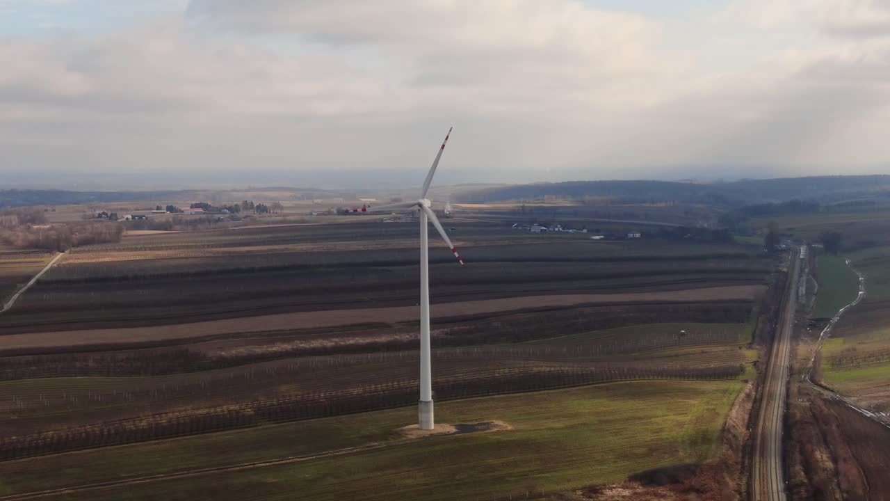 воздушная коляска к одной ветровой турбине, вращающейся в облачный облачный день в сельской местности польши