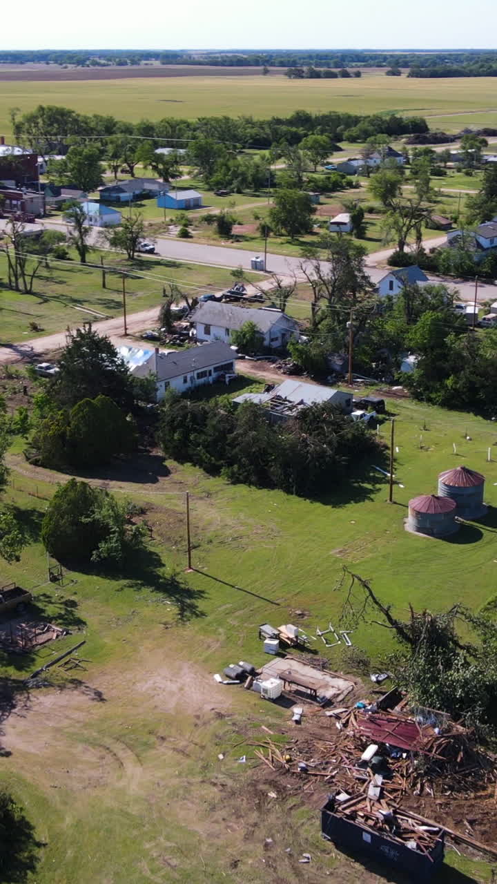 Vertical drone shot of a bulldozer clearing Tornado destruction, in Kansas, USA
