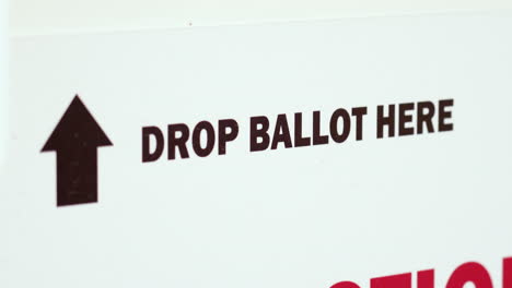 drop ballot here sign with arrow for mail-in election voting box close up