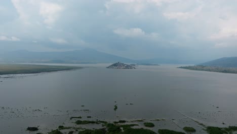 drone: dolly in shot of janitzio island at sunset from patzcuaro lake