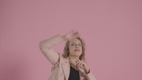 Studio-Shot-Of-Young-Woman-Having-Fun-Dancing-Against-Pink-Background-3