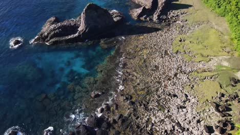 Surreal-crystal-blue-waters-swelling-over-stone-reef-and-unique-rocky-structures