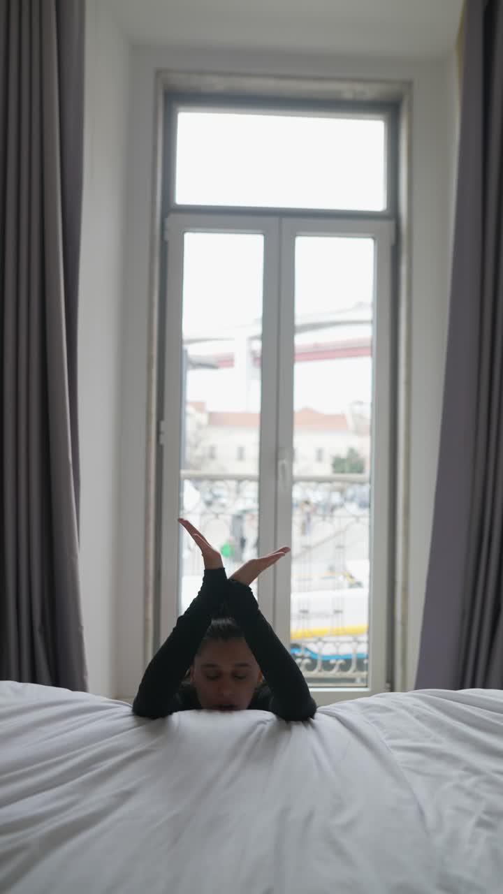 Woman resting on bed in hotel room