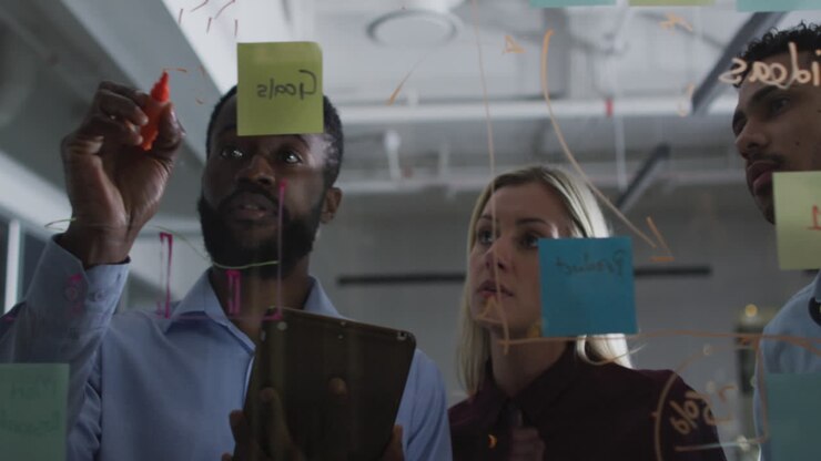 Video of four diverse male and female colleagues brainstorming ideas together at night in office