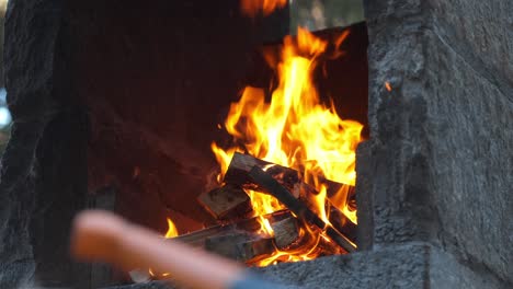 sharp axe resting on wooden block with fire blazing in the background