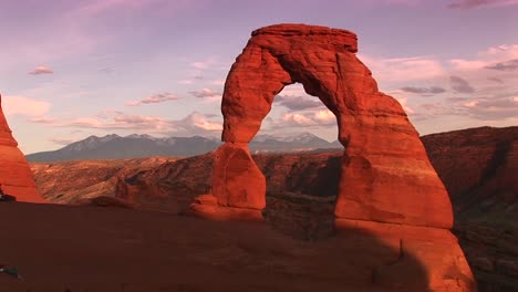 longshot of delicate arch in arches national park utah with mountains in the background