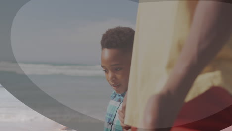 animation of shapes over african american man and his son at beach