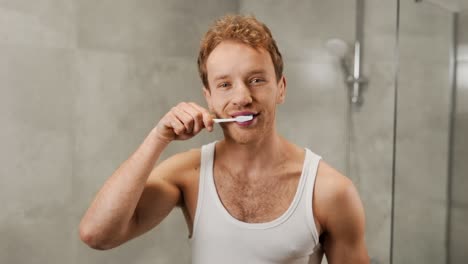 Handsome-young-man-in-the-bathroom-brushing-his-teeth