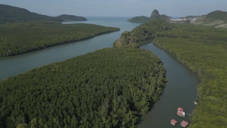 Increíble-Vista-Aérea-De-Un-Tranquilo-Pueblo-De-Manglares-Con-Barcos-Amarrados-A-Lo-Largo-De-Un-Río-Sinuoso-Junto-A-Un-Exuberante-Bosque-Verde