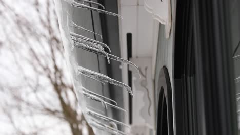 panning shot of icicles melting off roof in 4k