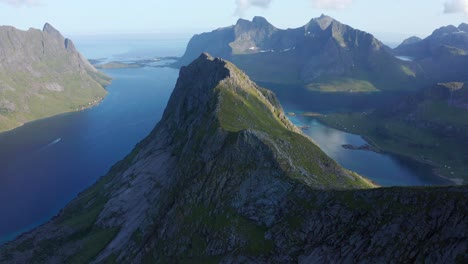 Drone-shot-of-Lofoten-steep-cliffs-and-mountains-rising-from-deep-blue-sea