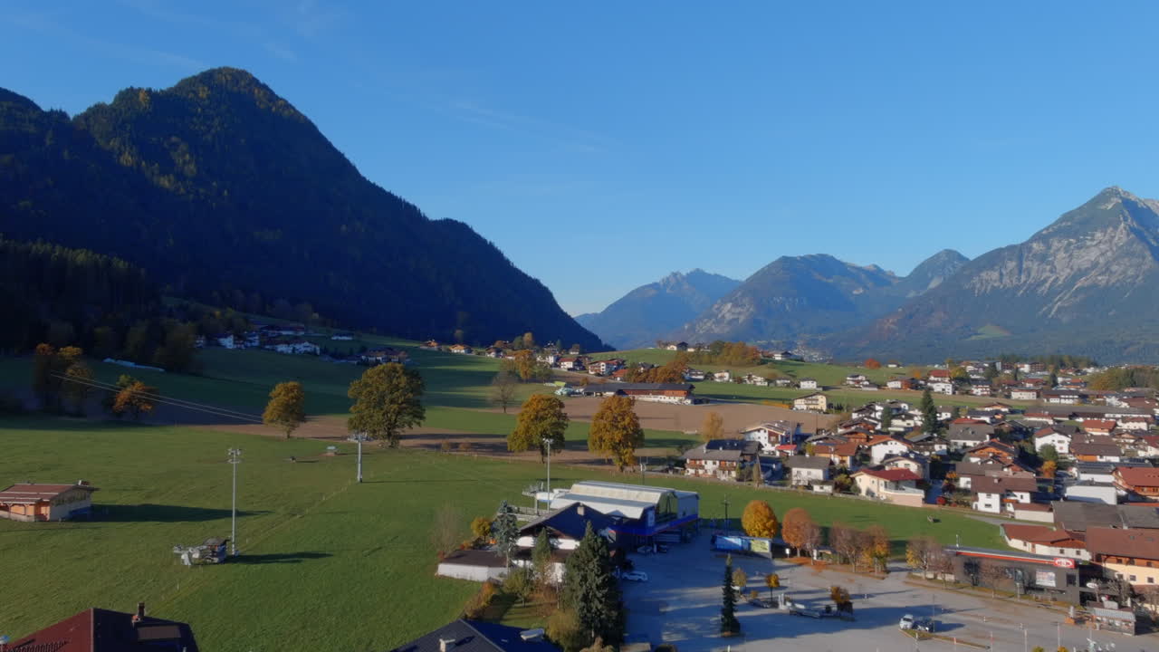 impresionante vuelo tranquilo hacia las montañas sobre la ciudad en austria, empuje de drones