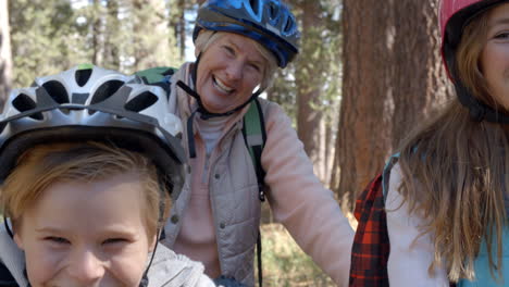 Close-up-shot,-children-and-grandparents-on-bikes-in-forest