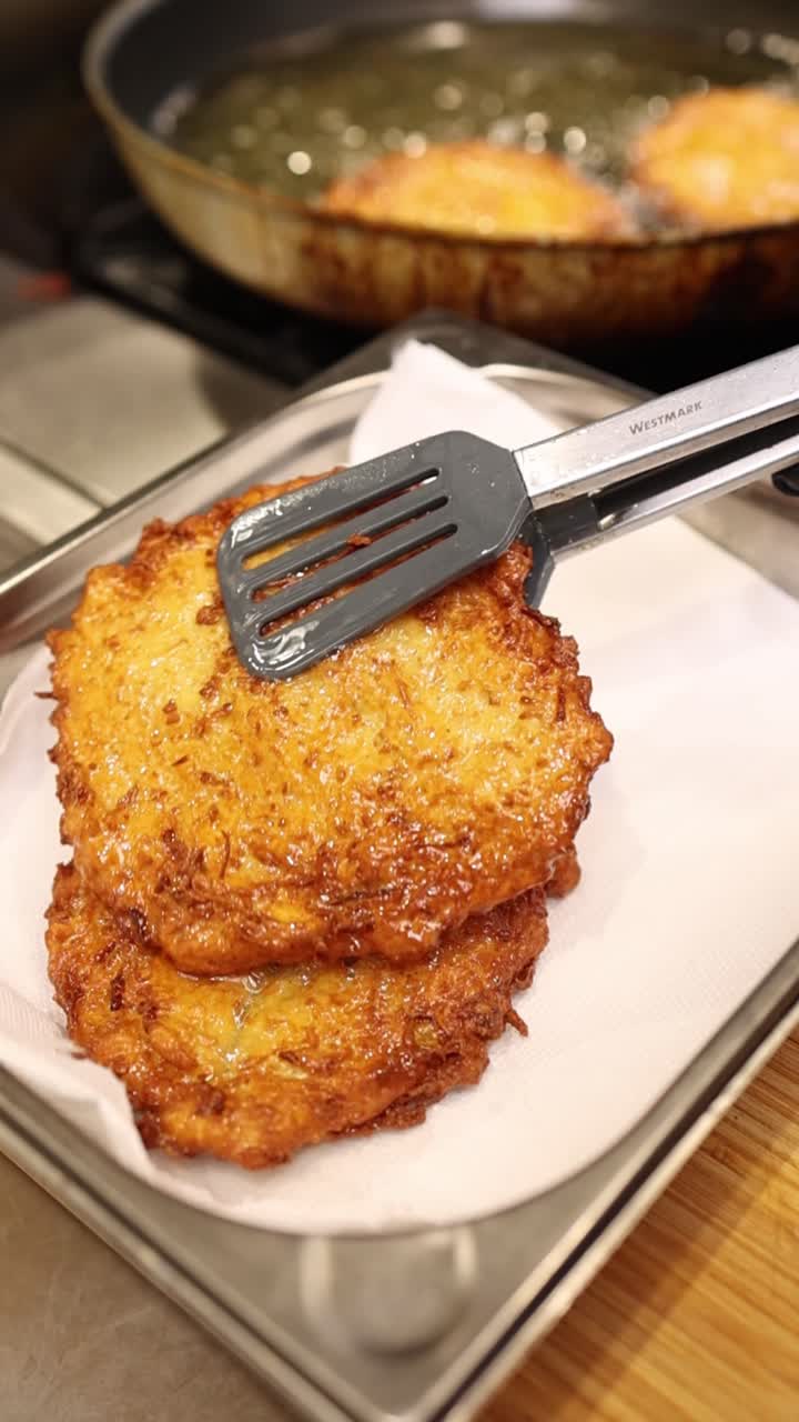 Frying and Stacking Golden Brown Potato Pancakes in a Kitchen