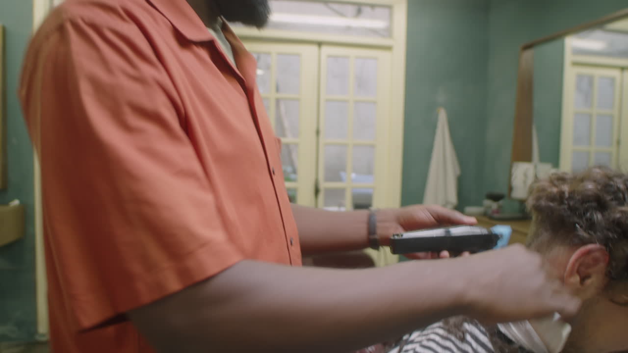 African American Barber Doing Haircut with Clippers and Comb