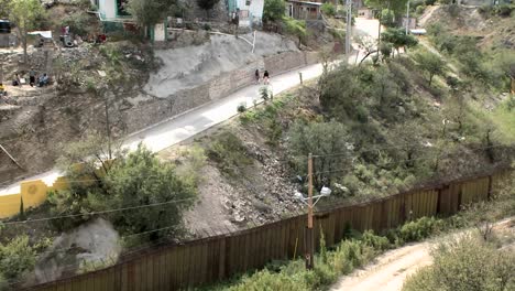 two people walk up a road outside a small town