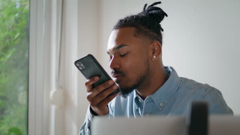 Black-hair-businessman-talking-phone-speaker-at-home.-Man-picking-cellphone-down