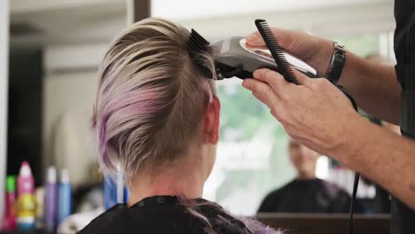 rückblick frau rasiert sich die haare beim friseur