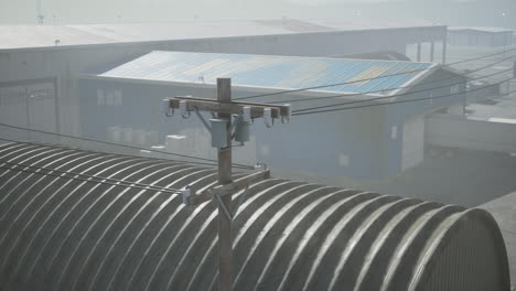 industrial area with utility pole and warehouses in fog