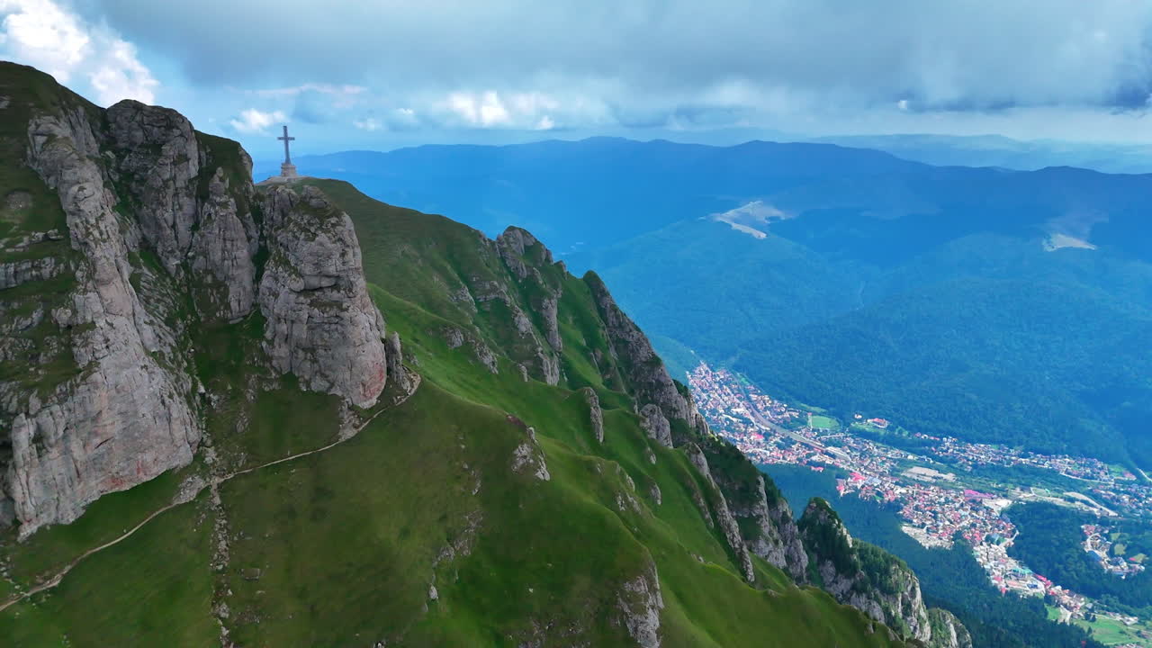 View from Caraiman Mountain summit over the valley. The summit of Caraiman Mountain offers a panoramic view across the valley and surrounding Carpathian peaks