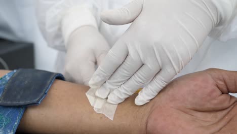 Doctor-Use-Syringe-Inject-Liquid-On-Asian-Man-Arm,-Close-Up