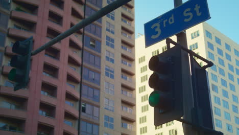 view traffic lights with blue sign number street on high buildings background.