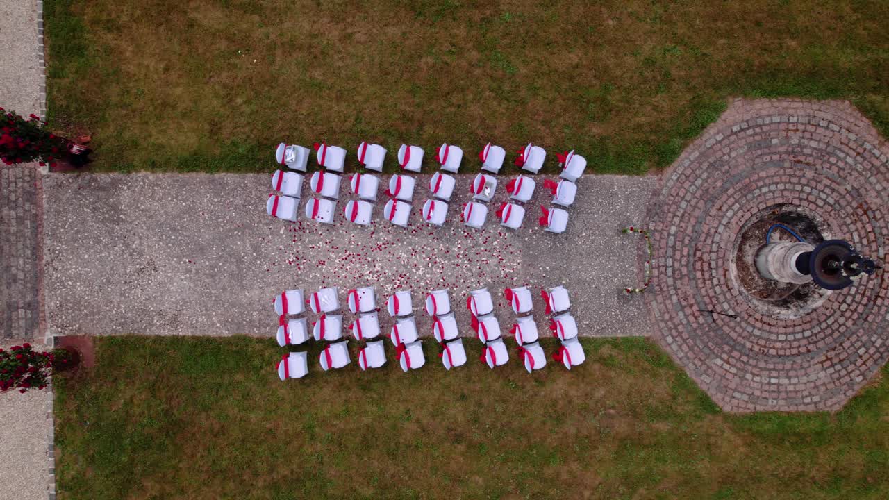 Aerial shot overhead an exterior wedding ceremony with petals in the aisle