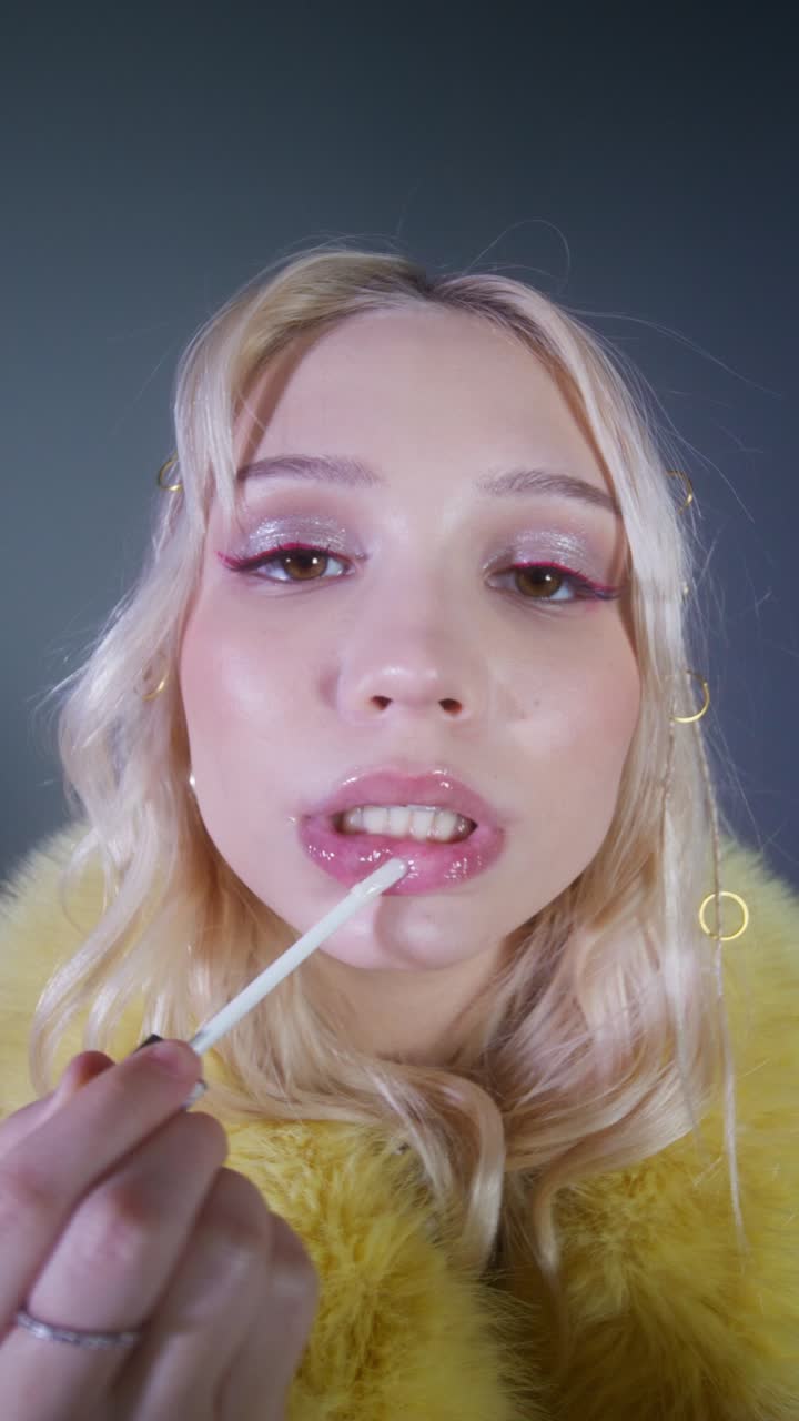 Blonde Woman Applying Lip Gloss