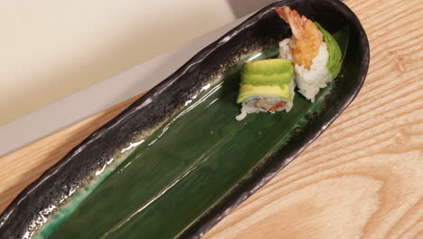 Hands-Of-A-Sushi-Chef-Carefully-Putting-Sushi-Rolls-And-Lined-Up-On-The-Plate