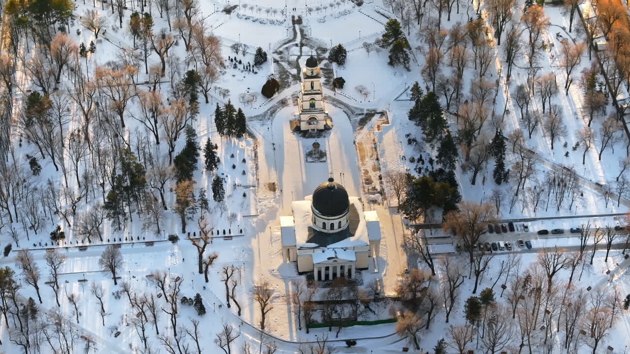 Aerial drone view of the Bell tower and the Metropolitan Cathedral of Christ's Nativity. City center covered in snow at sunset in Chisinau, Moldova