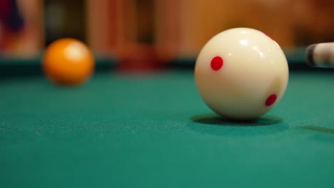 closeup of cue ball being shot into the solid yellow 1 ball and pocketing it in corner hole with a hard cut and almost missing with the ball rattling before it drops, green felt and no faces