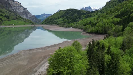 Water-stream-with-sandy-shores-and-mountains-in-the-background