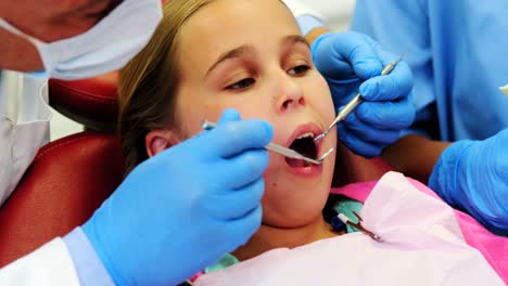 dentista y enfermera examinando a un paciente joven con herramientas