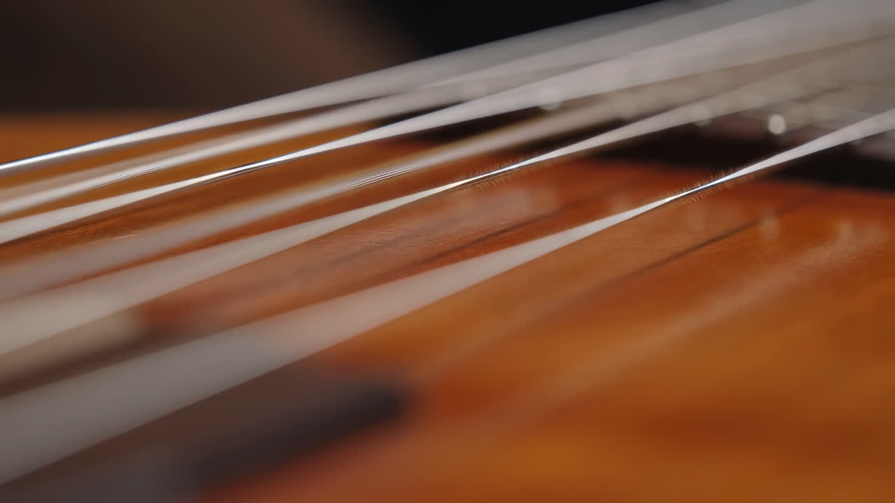 Primo piano di corde di chitarra che vibrano su uno strumento di legno