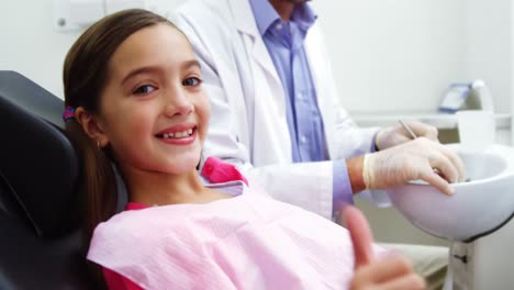 joven paciente sonriente sentado en la silla del dentista