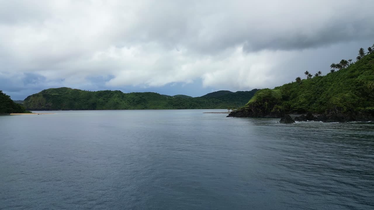푸른 바다 물과 바위 같은 열대 해안선 위에 구름이  ⁇ 인 회색 구름, 텍스트에 대한 공간