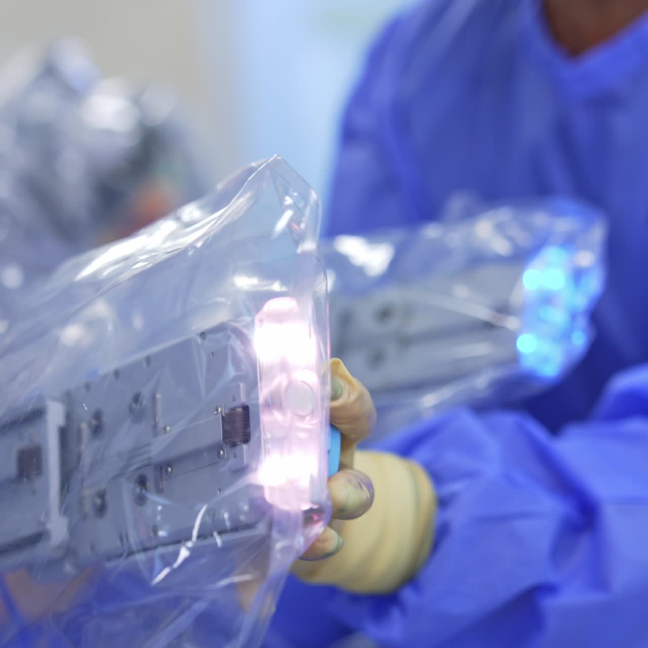 Medical assistant takes the device and attaches it to the robotic equipment covered in plastic. Close up. Blurred backdrop