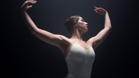 sensual dancer performing with raised hands indoors. ballerina dancing in class