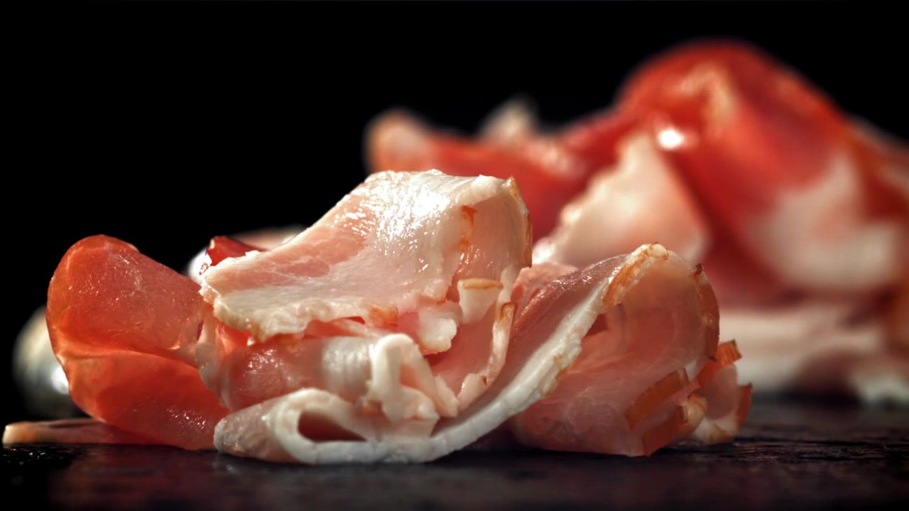 Fette di prosciutto crudo che cadono al rallentatore.