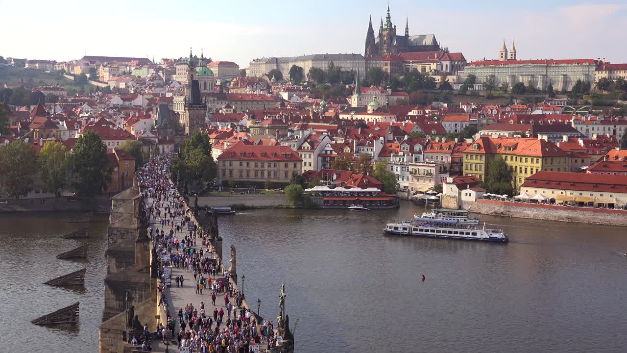 Splendida inquadratura diurna di contesto di folle che attraversano il Ponte Carlo sul fiume Moldava a Praga, Repubblica Ceca