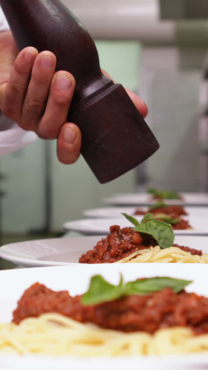 chef aderezando cenas de espagueti con pimienta negra
